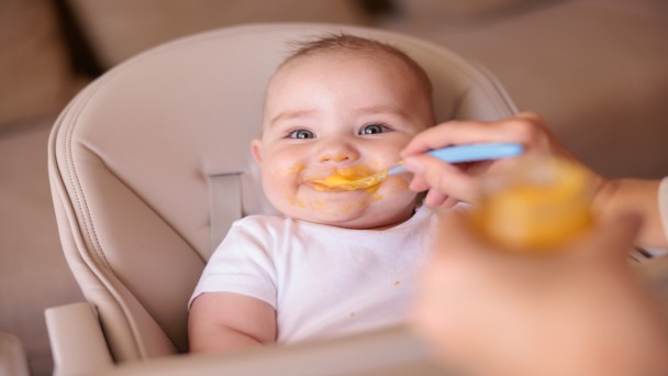 תינוק טועם אוכל חדש בפעם הראשונה במהלך שלב טעימות לתינוק